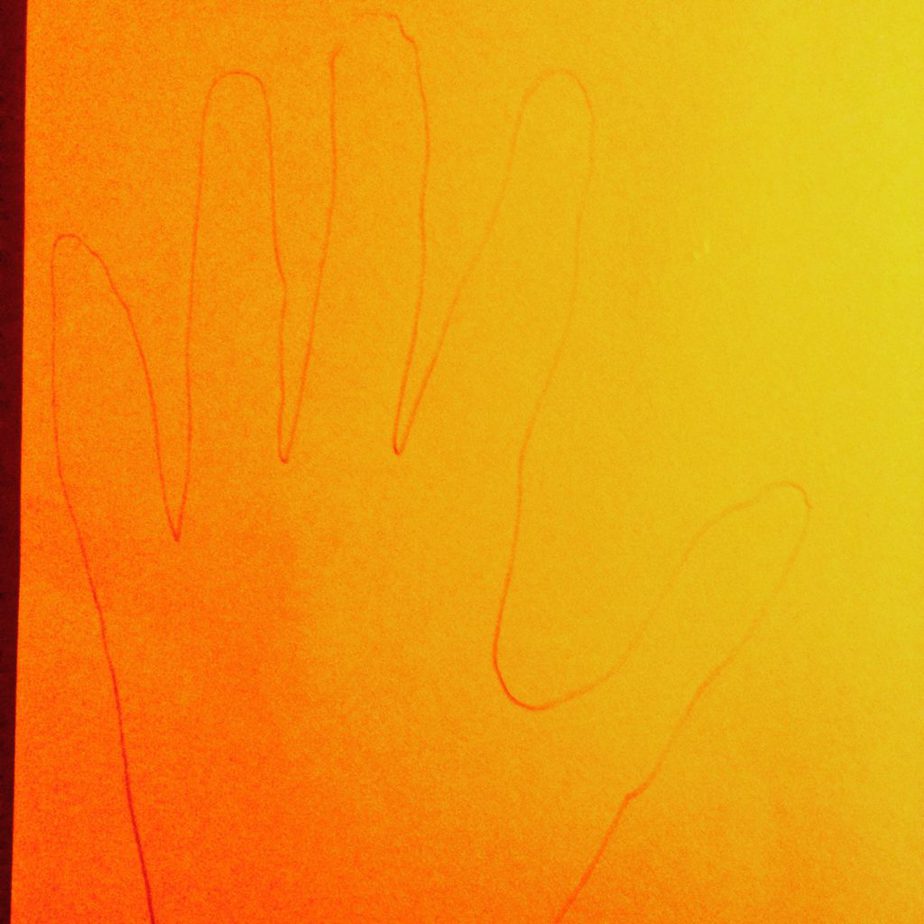 Draw around your hand on each colour of card and cut it out.